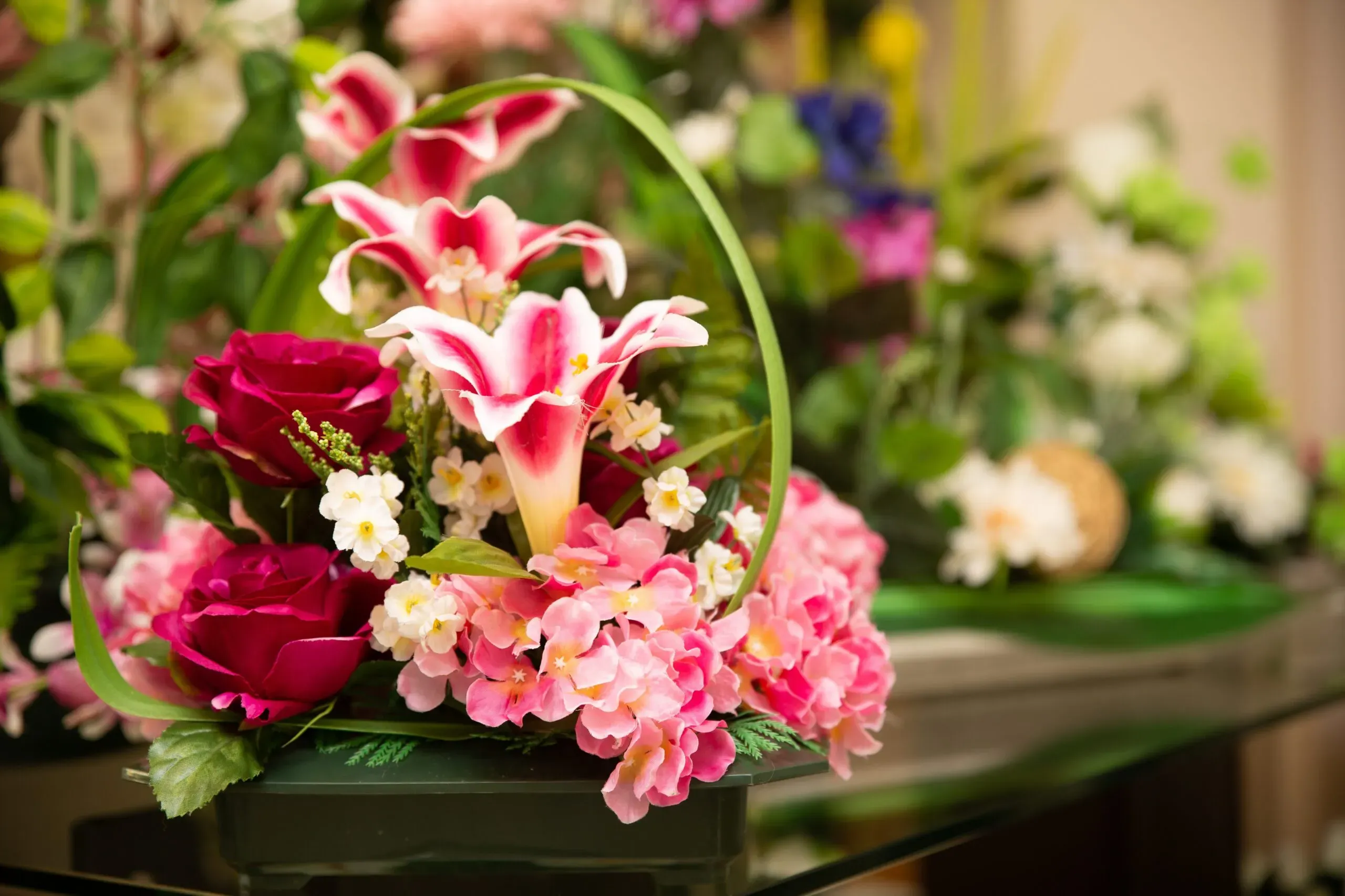 Composition florale funéraire avec lys roses et roses rouges.