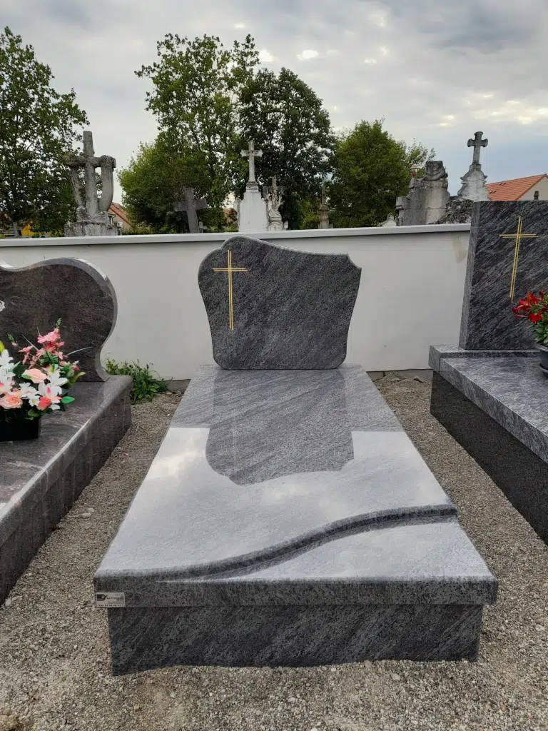 Monument funéraire en granit gris poli avec stèle gravée d'une croix.