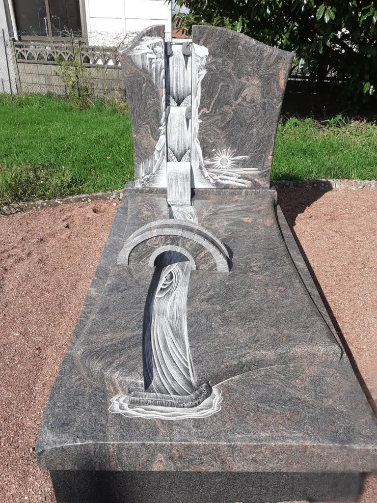 Pierre tombale originale sculptée d'un pont et d'une cascade en granit.