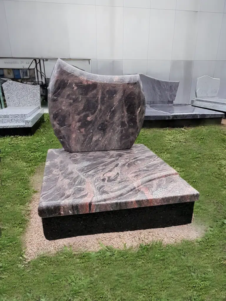 Monument cinéraire compact en granit rose aux reflets marbrés.
